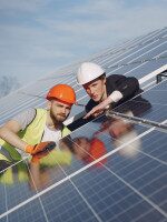 Männer beraten sich am Rand einer Solaranlage